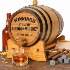 Mini oak bourbon aging barrel on wooden stand with whiskey glass, bottle, cigars, and whiskey stones for home aging and flavor infusion.