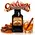 Cinnamon Whiskey Liqueur Essence pouch by Swish Barrel with cinnamon sticks and ground cinnamon, alongside a crystal glass of amber whiskey over ice with a cinnamon garnish.