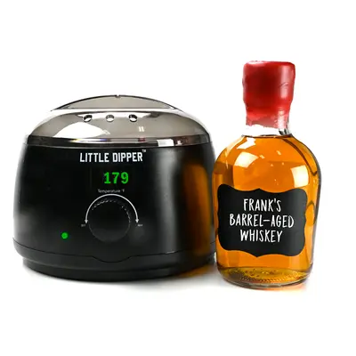 Little Dipper wax warmer next to a finished home-aged whiskey bottle sealed with red bottle wax.