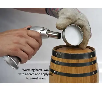 Demonstration of heating American Barrel Wax with a culinary torch and applying melted wax to seal an oak whiskey aging barrel seam to stop leaks.